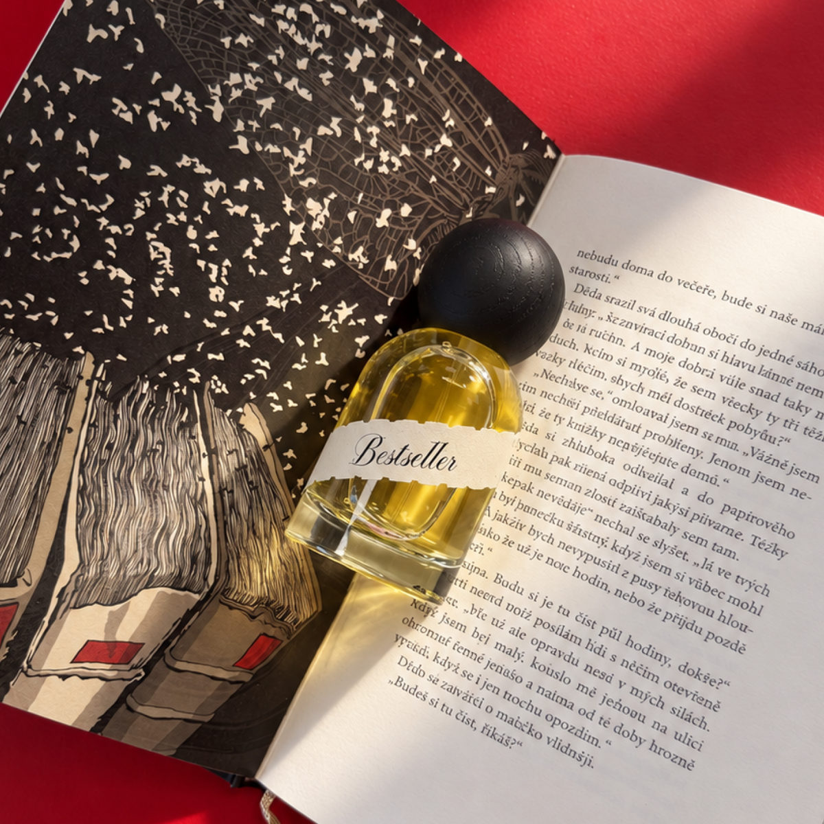 Parfum Bestseller — fľaška položená na otvorenej knihe