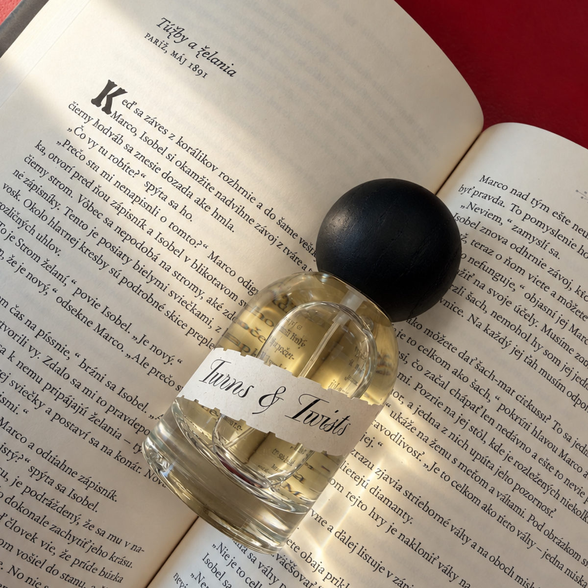 Parfum Turns & Twists — fľaška položená na otvorenej knihe