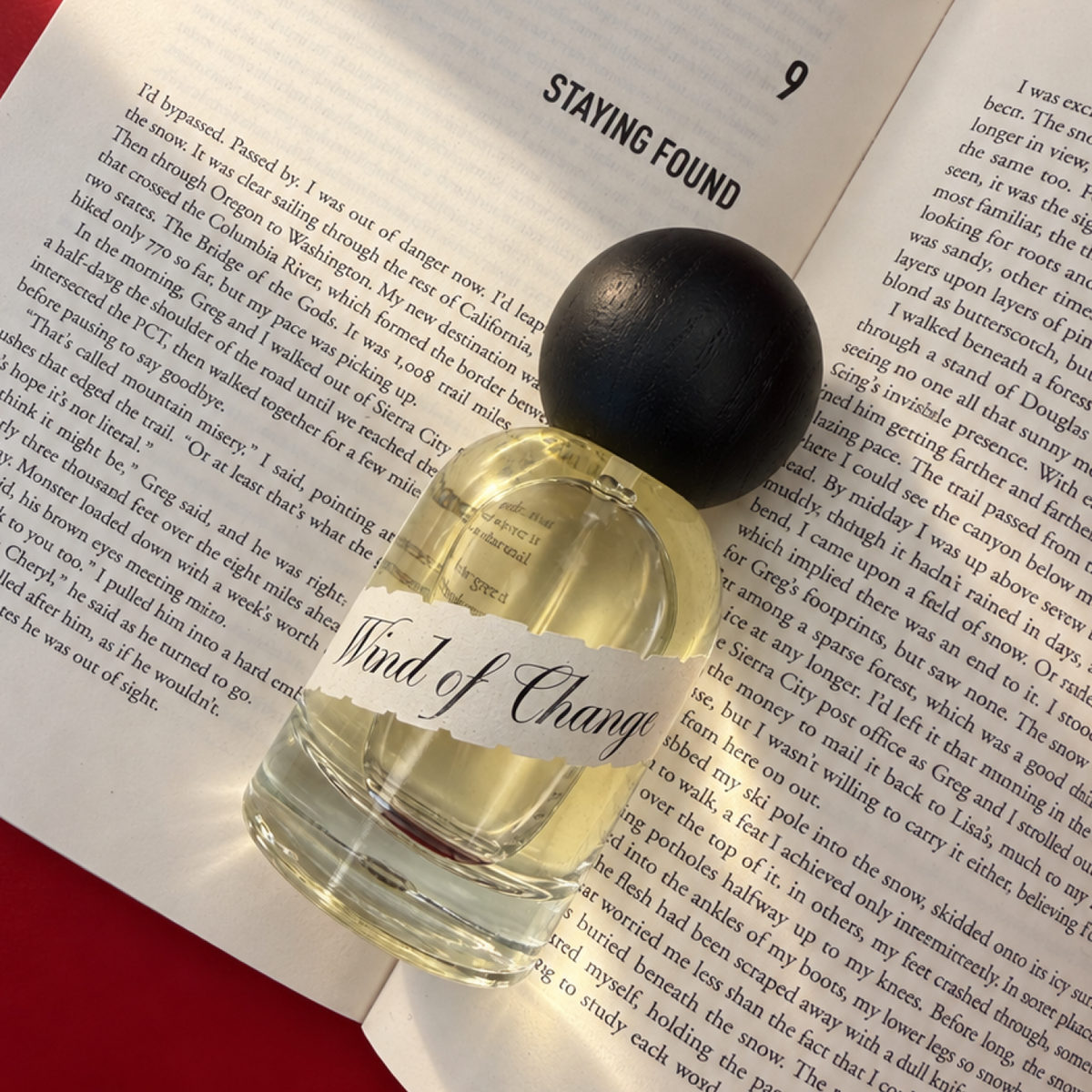 Parfum Wind of Change — fľaška položená na otvorenej knihe